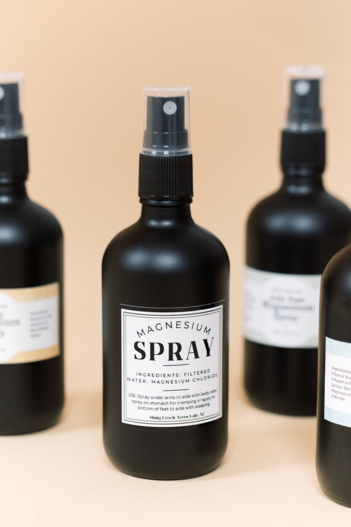 Magnesium spray bottle with clear mist sprayer, front bottle centered among others