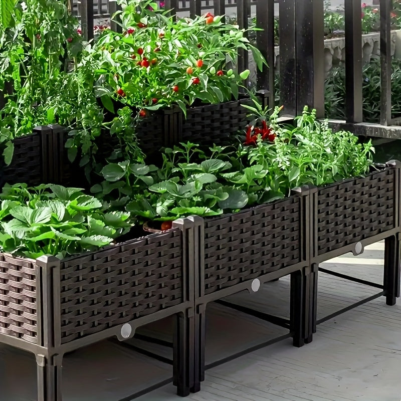 Outdoor raised planter box with dark woven sides and mixed leafy plants