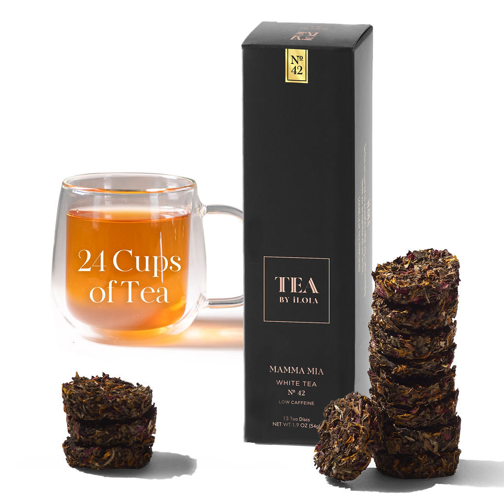 Mamma Mia No. 42 tea box and compressed tea discs beside a glass of brewed tea