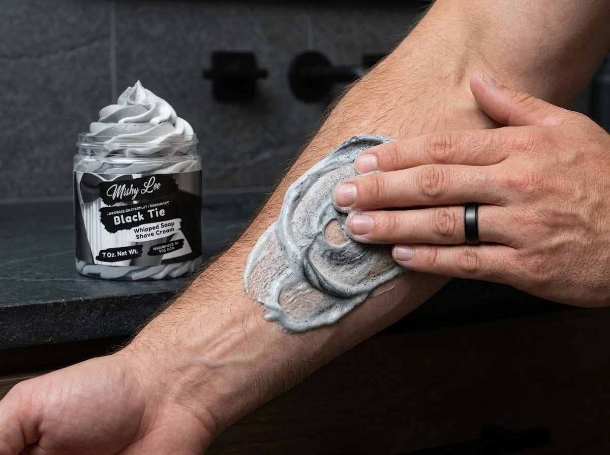 Gray whipped shaving foam spread on forearm by hand, with jar in background