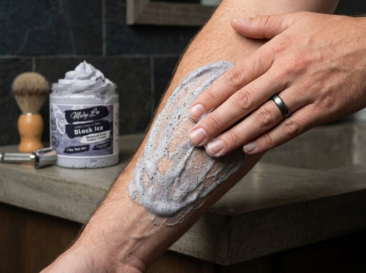 Man shaving with thick light purple foam spread on cheek and neck
