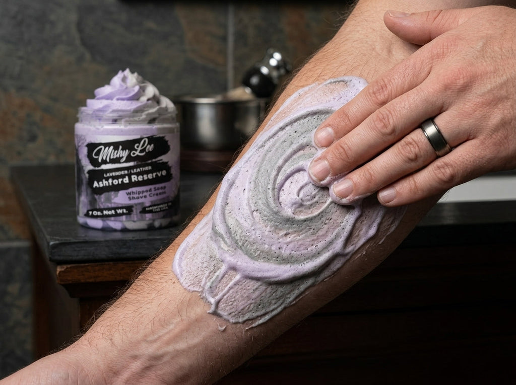 Man lathering his leg with purple whipped soap/shave cream, jar nearby