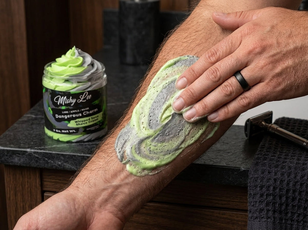 Man shaving: hand spreads green-and-gray whipped soap on forearm