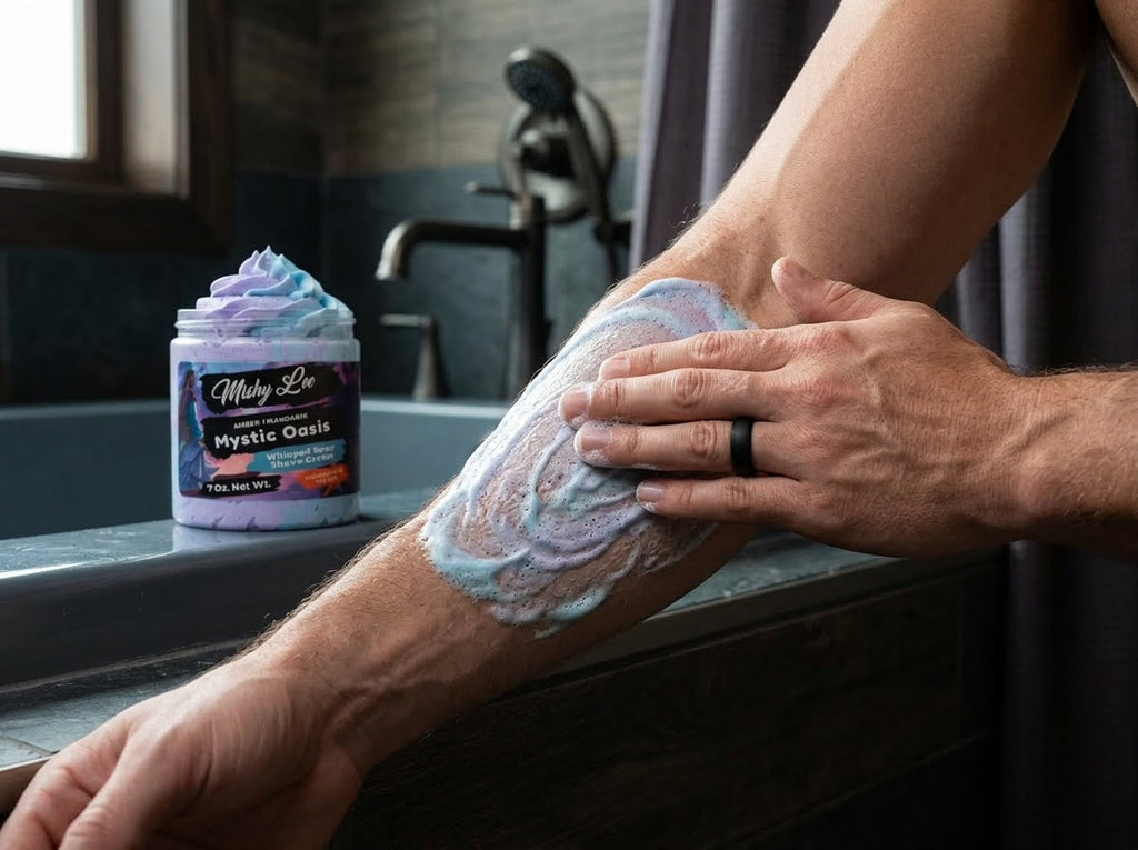 Hands spreading purple-and-blue whipped shave cream on a leg; jar nearby.