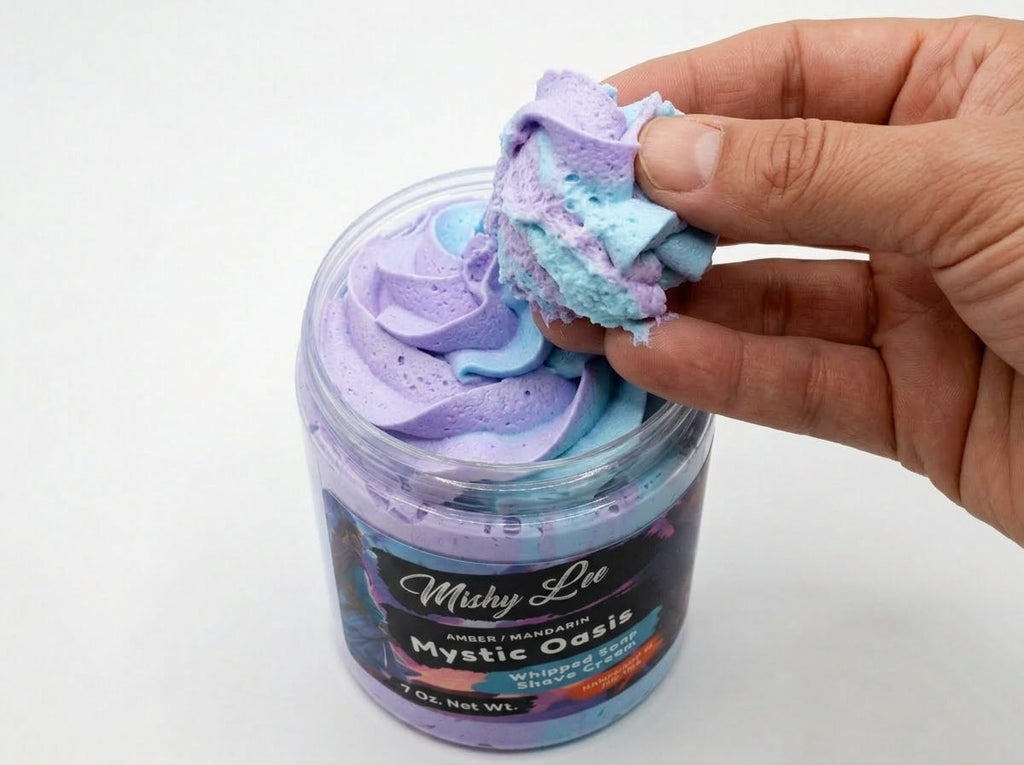Hand holding a scoop of purple-and-blue whipped shave cream foam above jar.