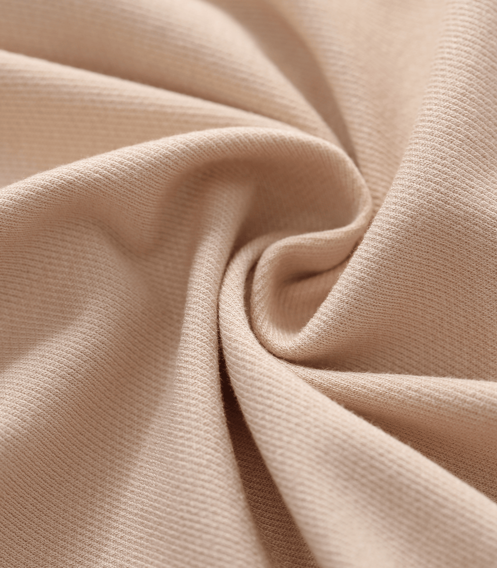 Close-up fabric texture of maternity trouser pants in light beige with fine weave