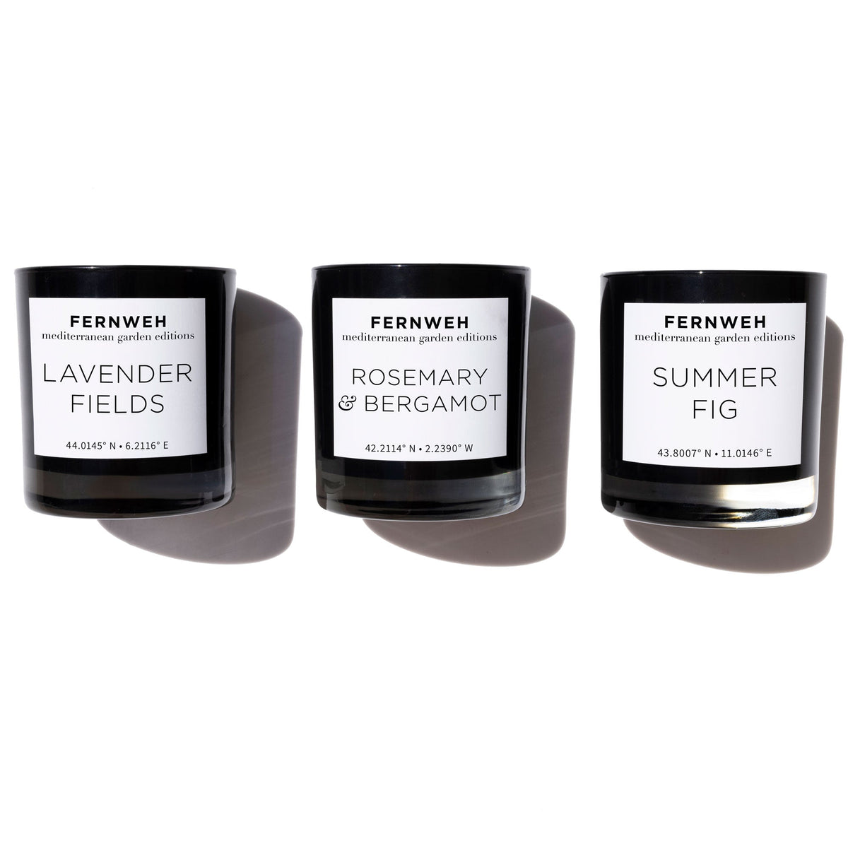 Three black glass candles labeled Lavender Fields, Rosemary & Bergamot, and Summer Fig