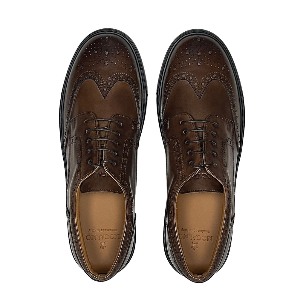 Pair of men's brown wingtip oxford shoes with laces and perforated brogue pattern