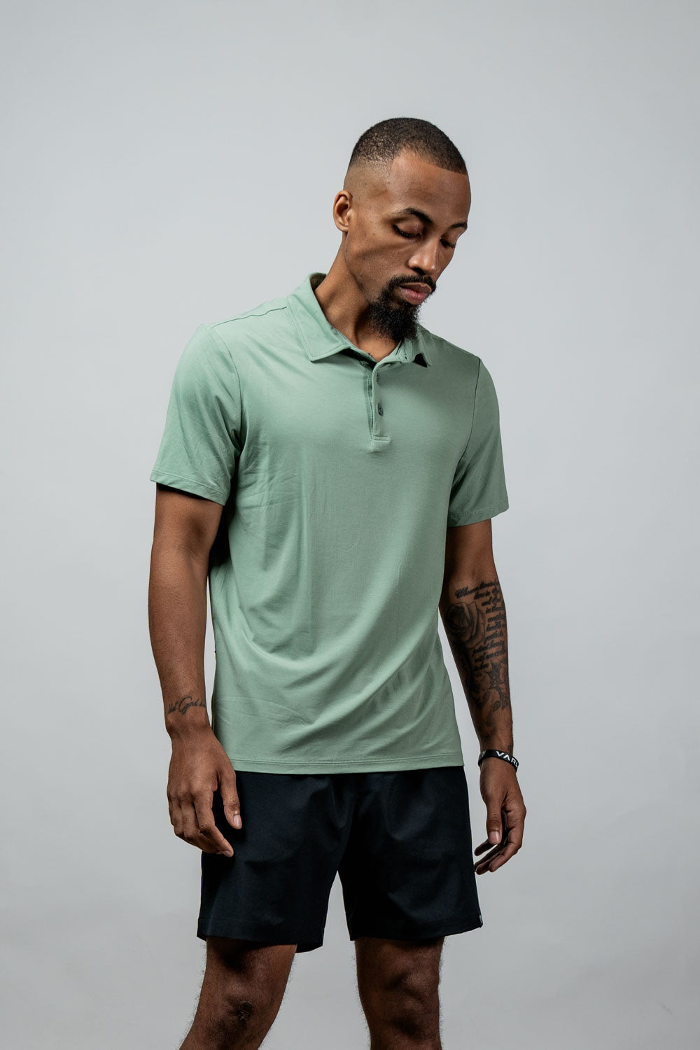 Men's low-light olive polo shirt with short sleeves and button placket, front view.
