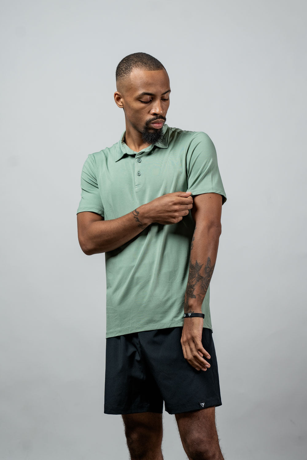 Men's olive polo shirt with short sleeves, collar, and button placket