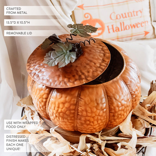 Embossed orange metal pumpkin with open lid and decorative green leaf topper