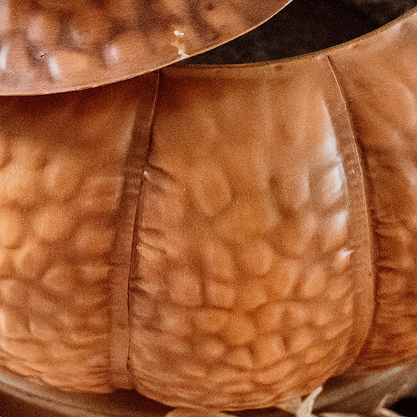 Embossed orange metal pumpkin body with lid edge and vertical seam lines