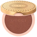 Gucci glow illuminating gel-powder highlighter compact with gold lid and dark bronze powder.