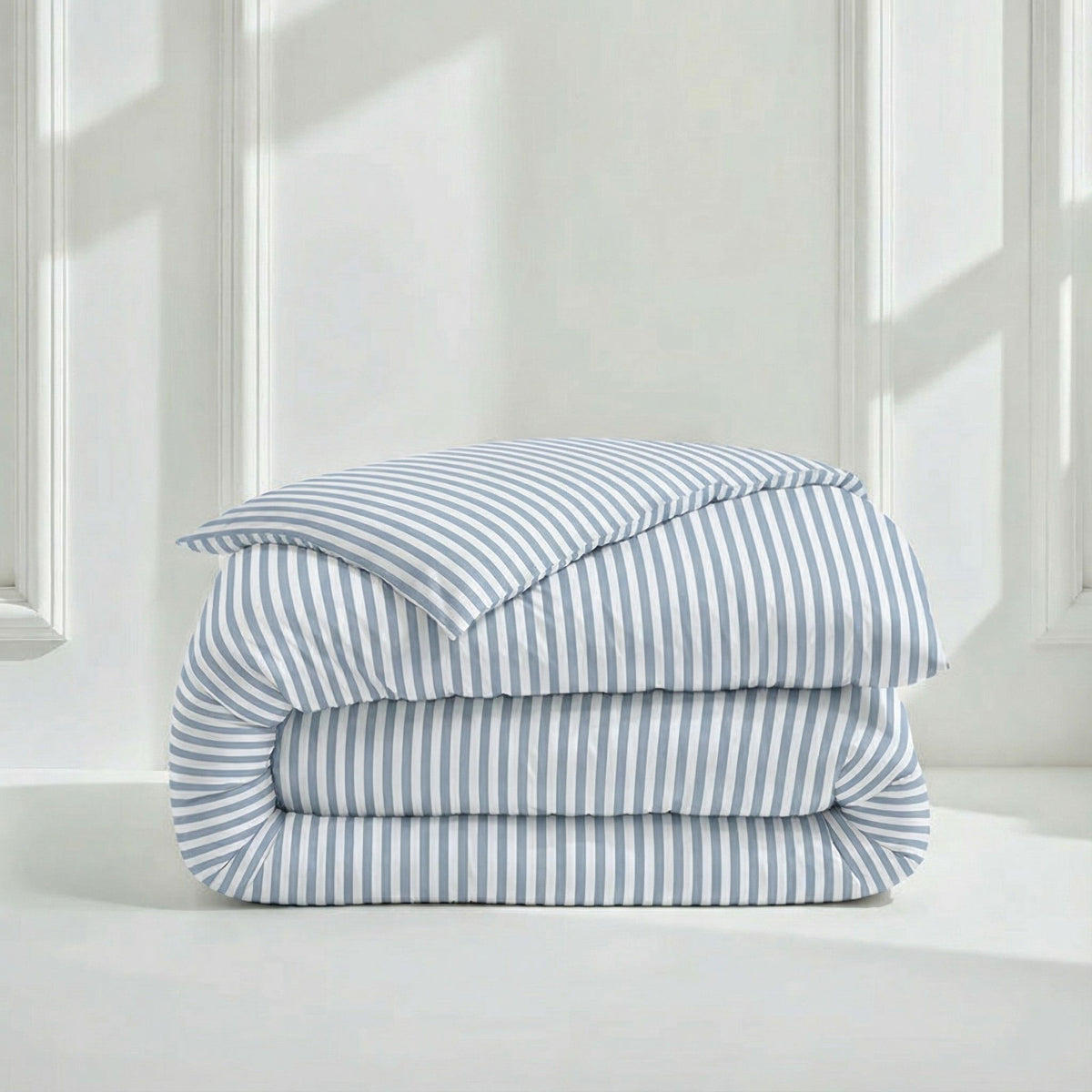 Blue and white striped sateen bedding bundle with stacked folded duvet and pillows