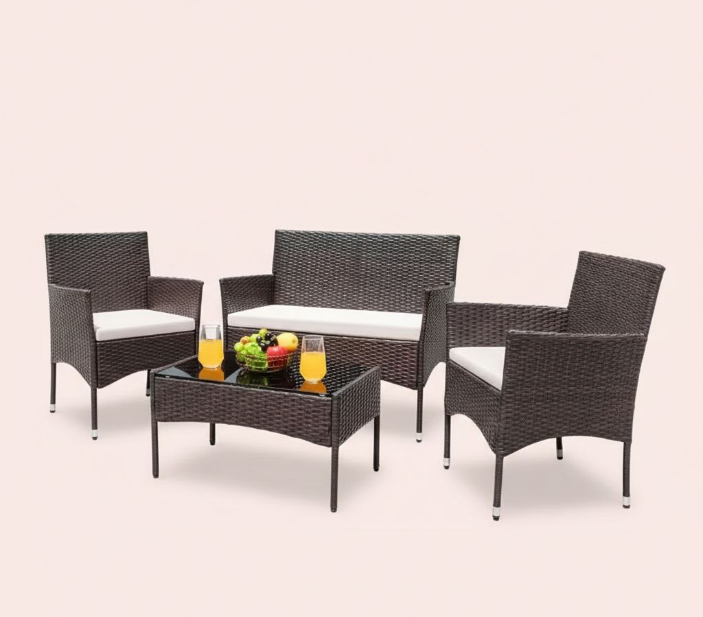 Dark brown wicker patio conversation set with white seat cushions, sofa, two chairs, coffee table