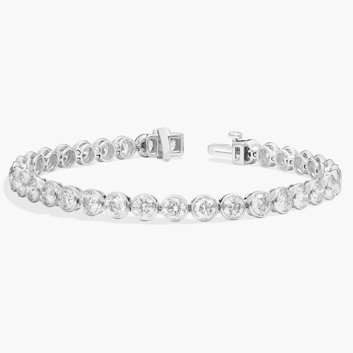 Silver-tone tennis bracelet featuring bezel-set round stones and a secure clasp closure.
