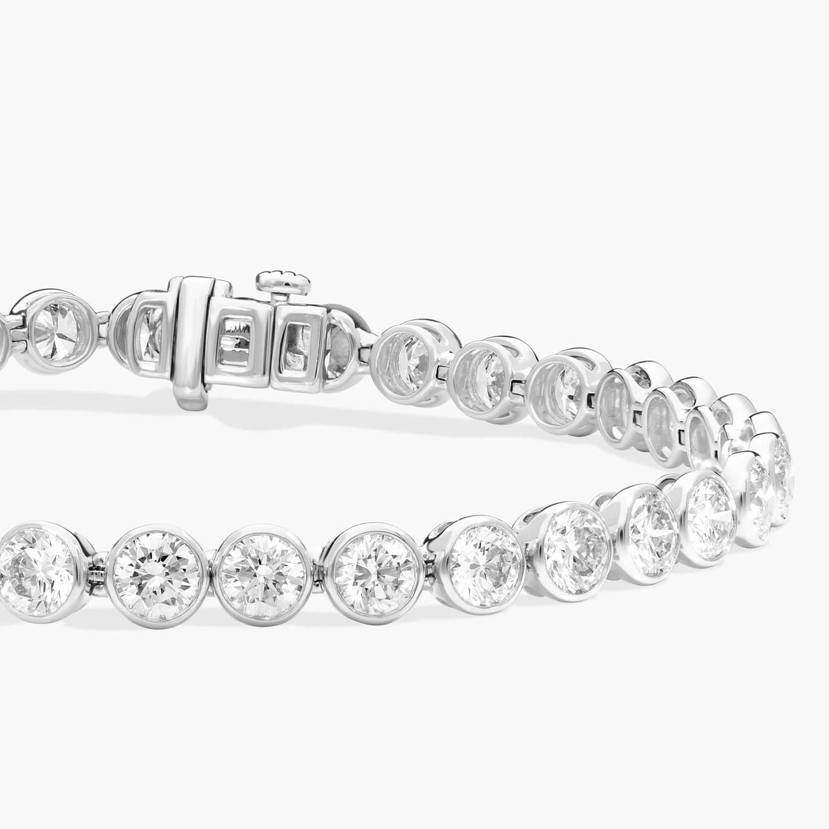 Silver-tone round-stone bezel tennis bracelet shown from side with clasp detail visible.