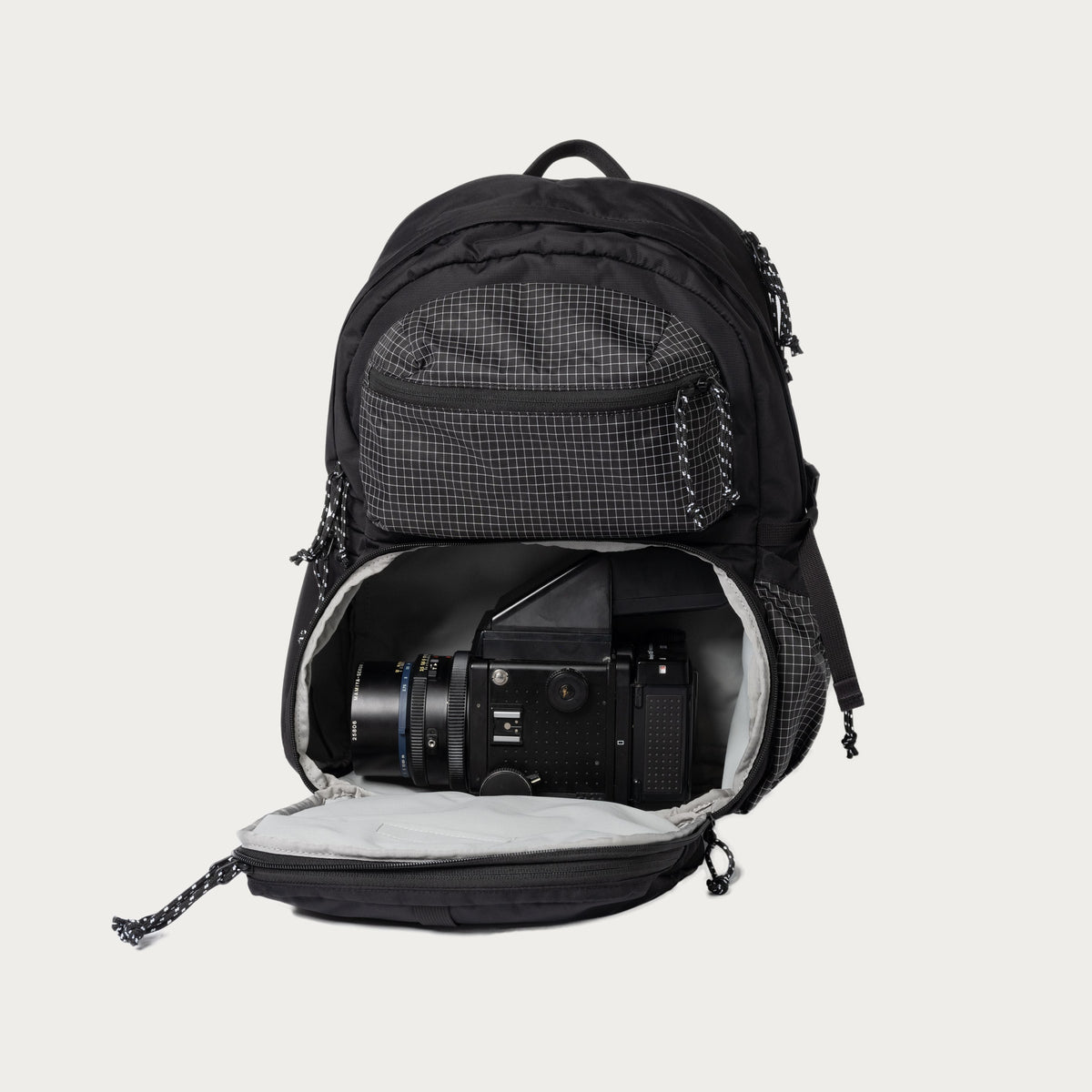 Black convertible backpack open, with padded interior and camera-gear compartment