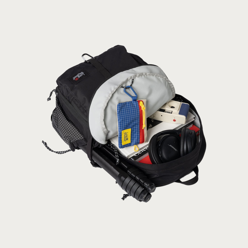 Black convertible backpack open side, showing storage pockets and small electronics