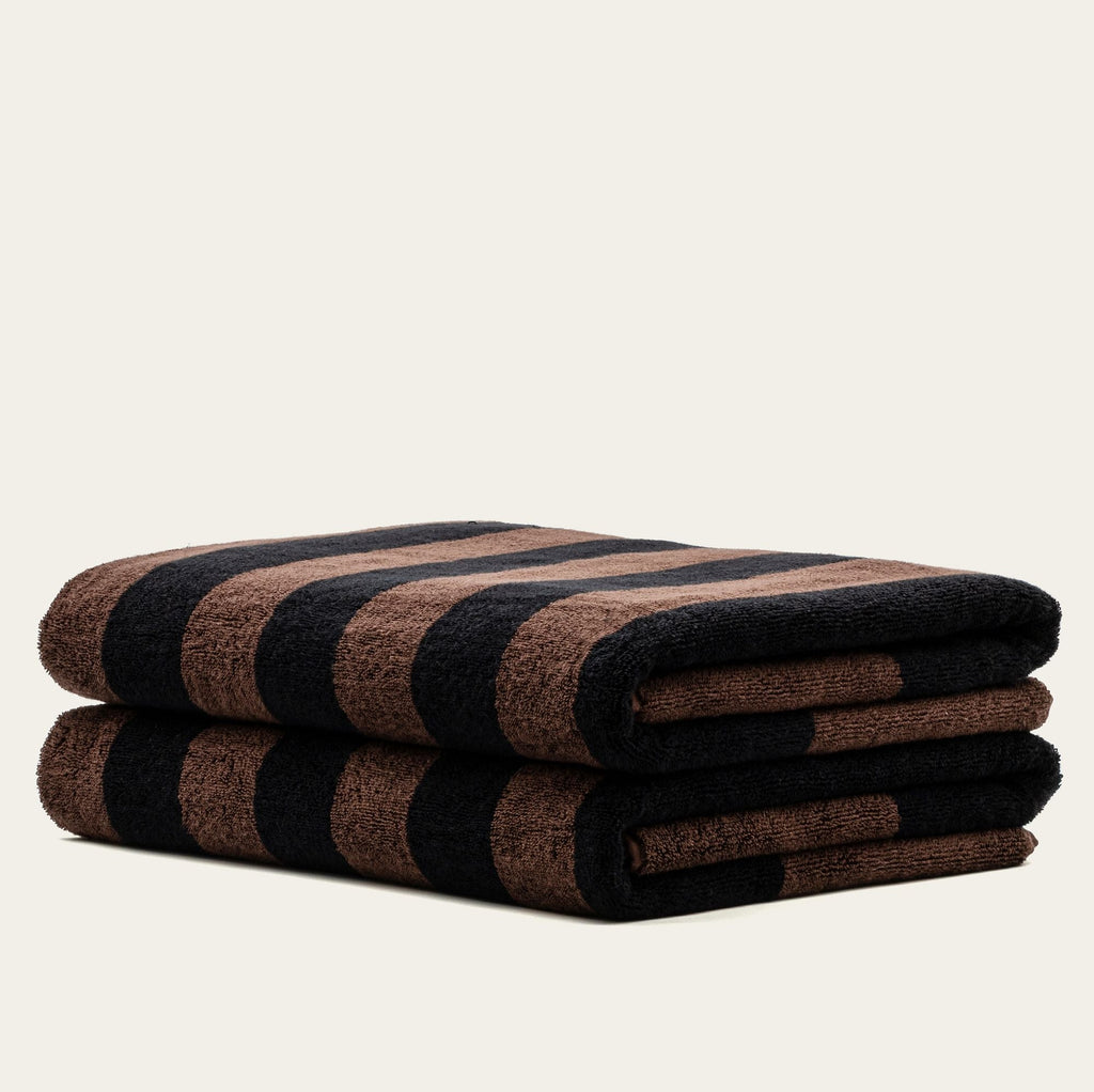 Rolled stack of cotton towels in tobacco brown and black plaid stripes