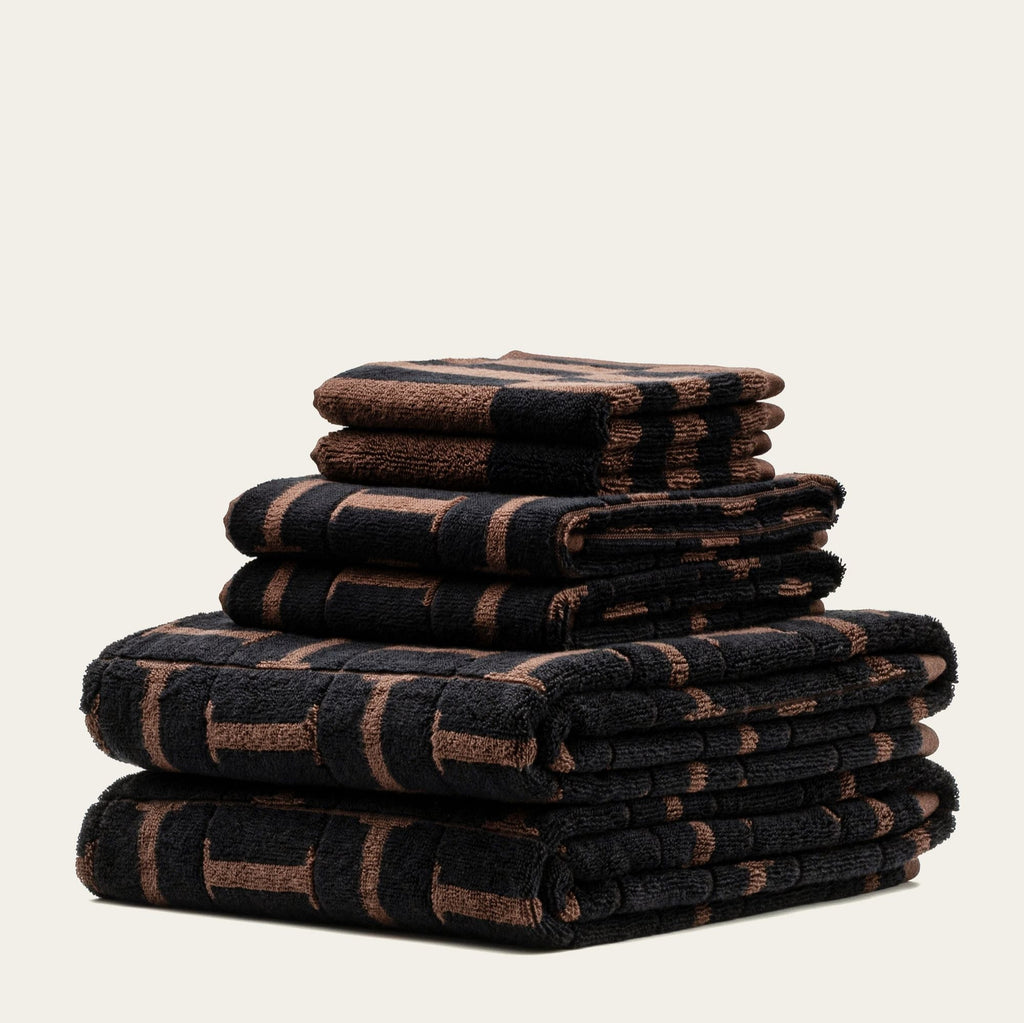 Piled terry cotton towels in tobacco and black with repeating geometric grid pattern