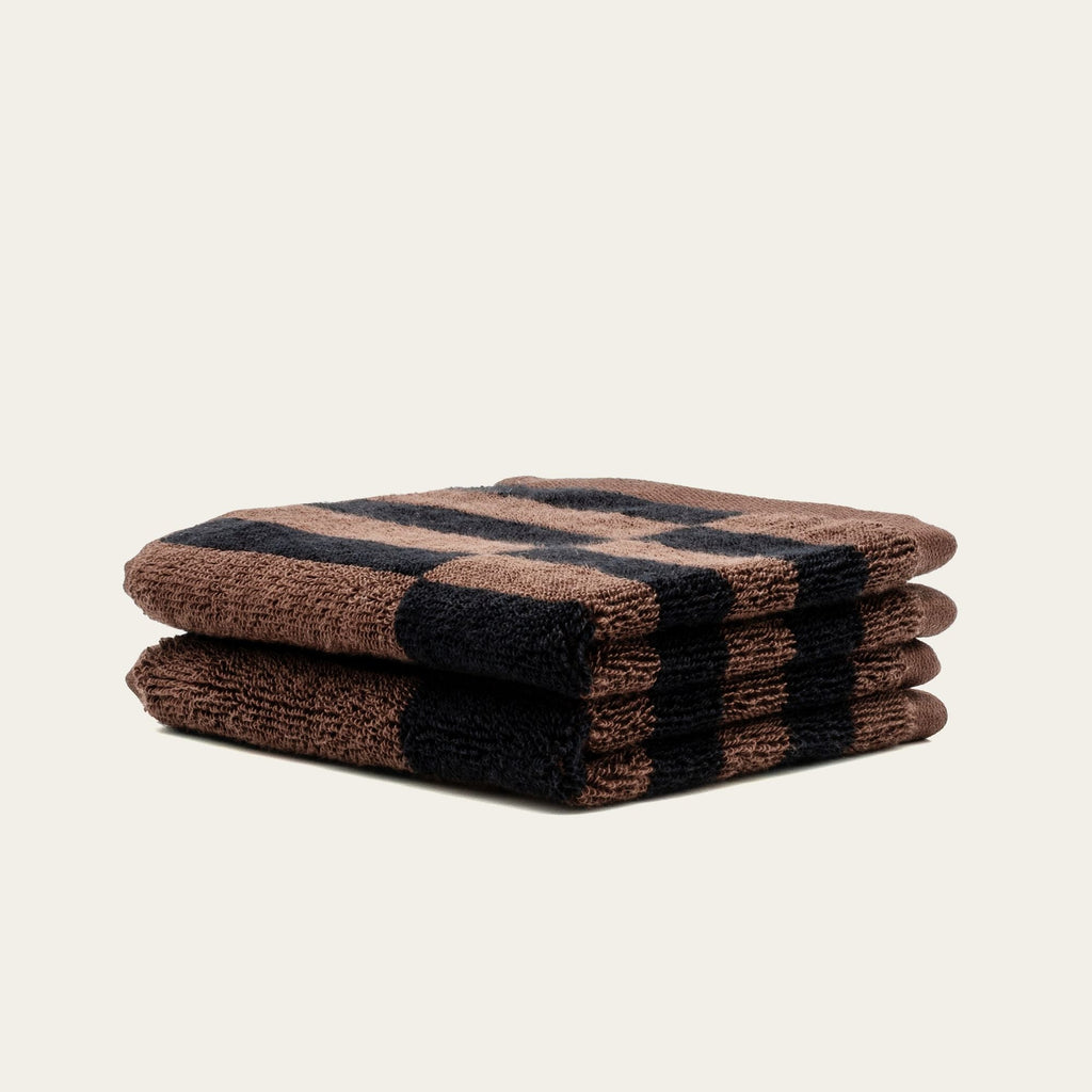 Two folded cotton towels with tobacco brown and black plaid stripe pattern