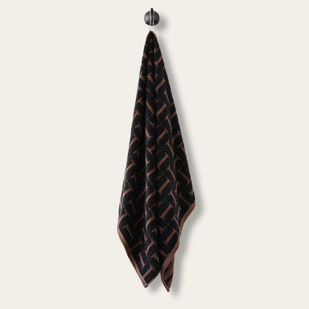 Single hanging terry cotton towel in tobacco and black woven geometric pattern