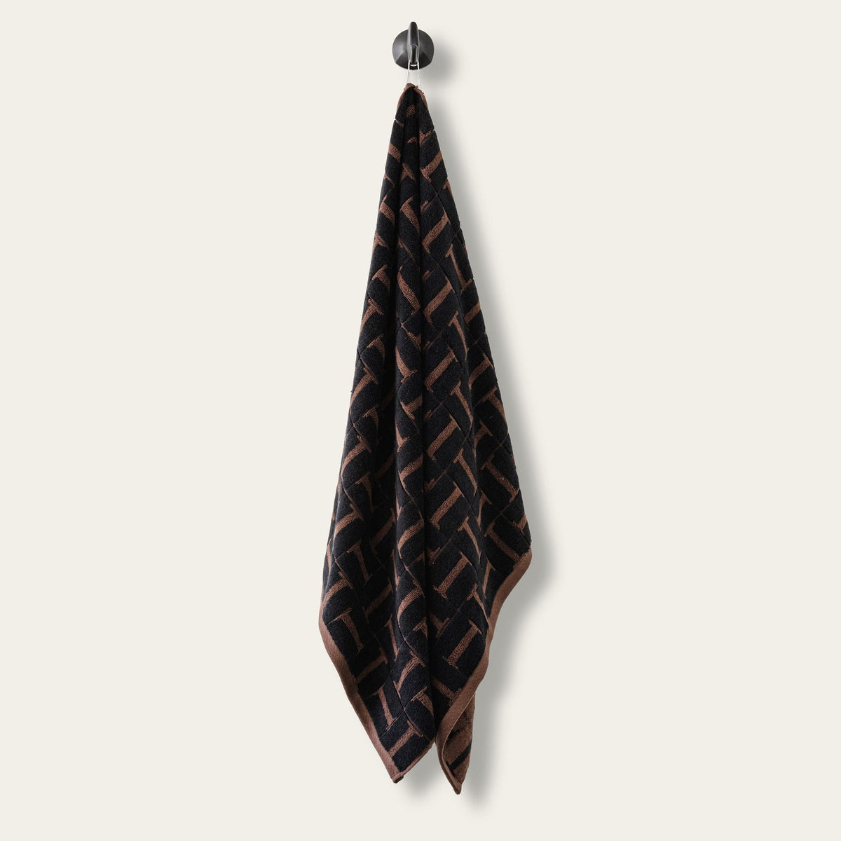 Single hanging terry cotton towel in tobacco and black woven geometric pattern