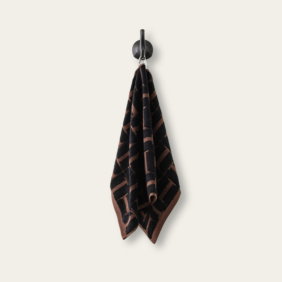 Two hanging terry cotton towels in tobacco and black woven geometric pattern