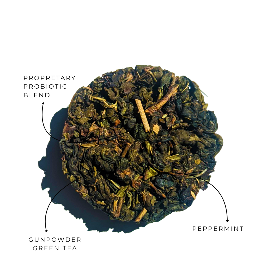 Top view of a compressed Moroccan mint green tea disc with visible leaf pieces