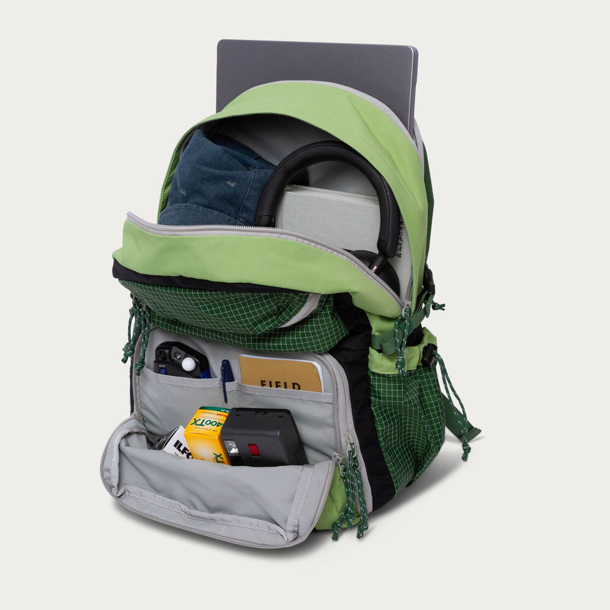 Moss green convertible backpack open, showing camera and small accessory pouches