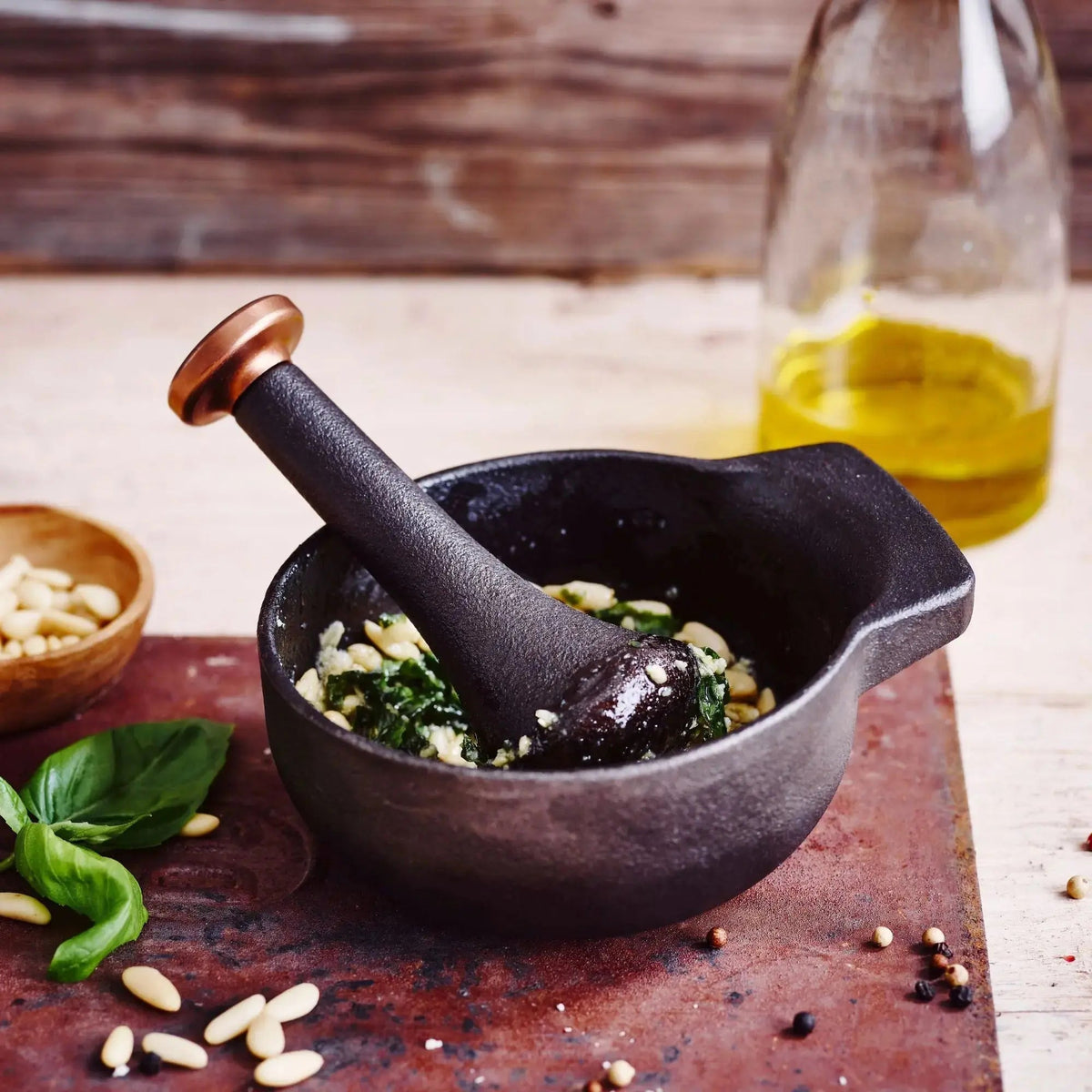 Black enameled mortar with pestle, filled with herbs and seasoning