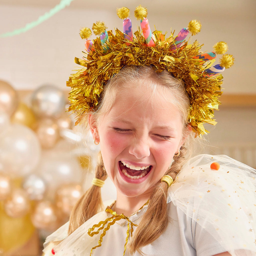 Gold tinsel headband with multicolor candle toppers and yellow pom-poms on top