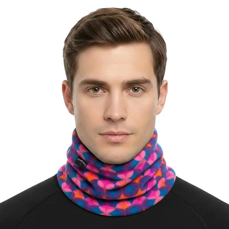 Fleece neck warmer on model: multicolor geometric pattern in bright magenta and blue