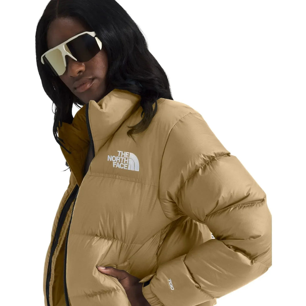 Women's khaki puffer jacket close-up with The North Face logo and insulated baffles