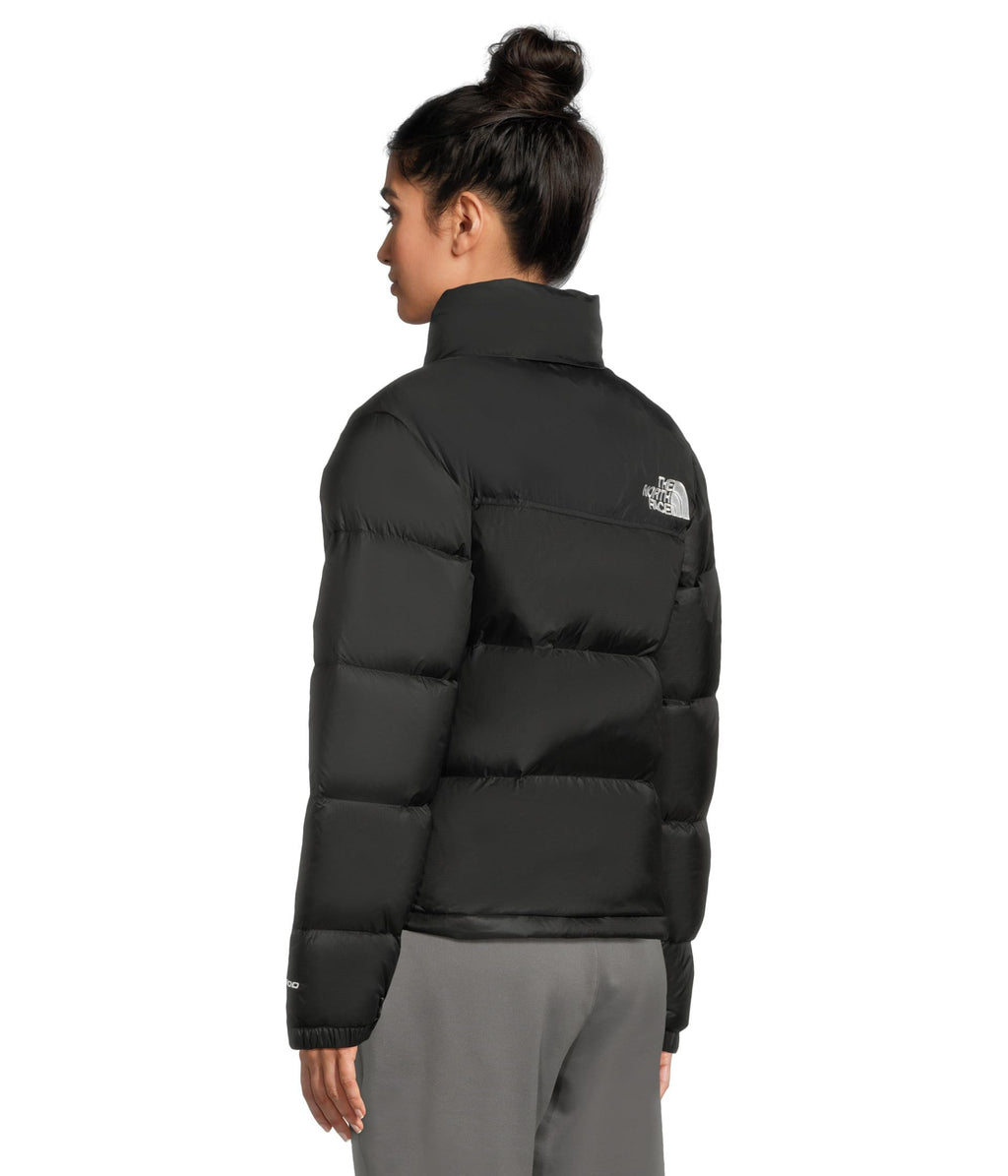 Women’s black puffer jacket back view with logo patch on upper arm