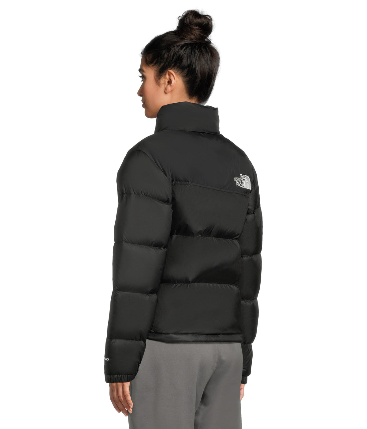 Women’s black puffer jacket back view with logo patch on upper arm