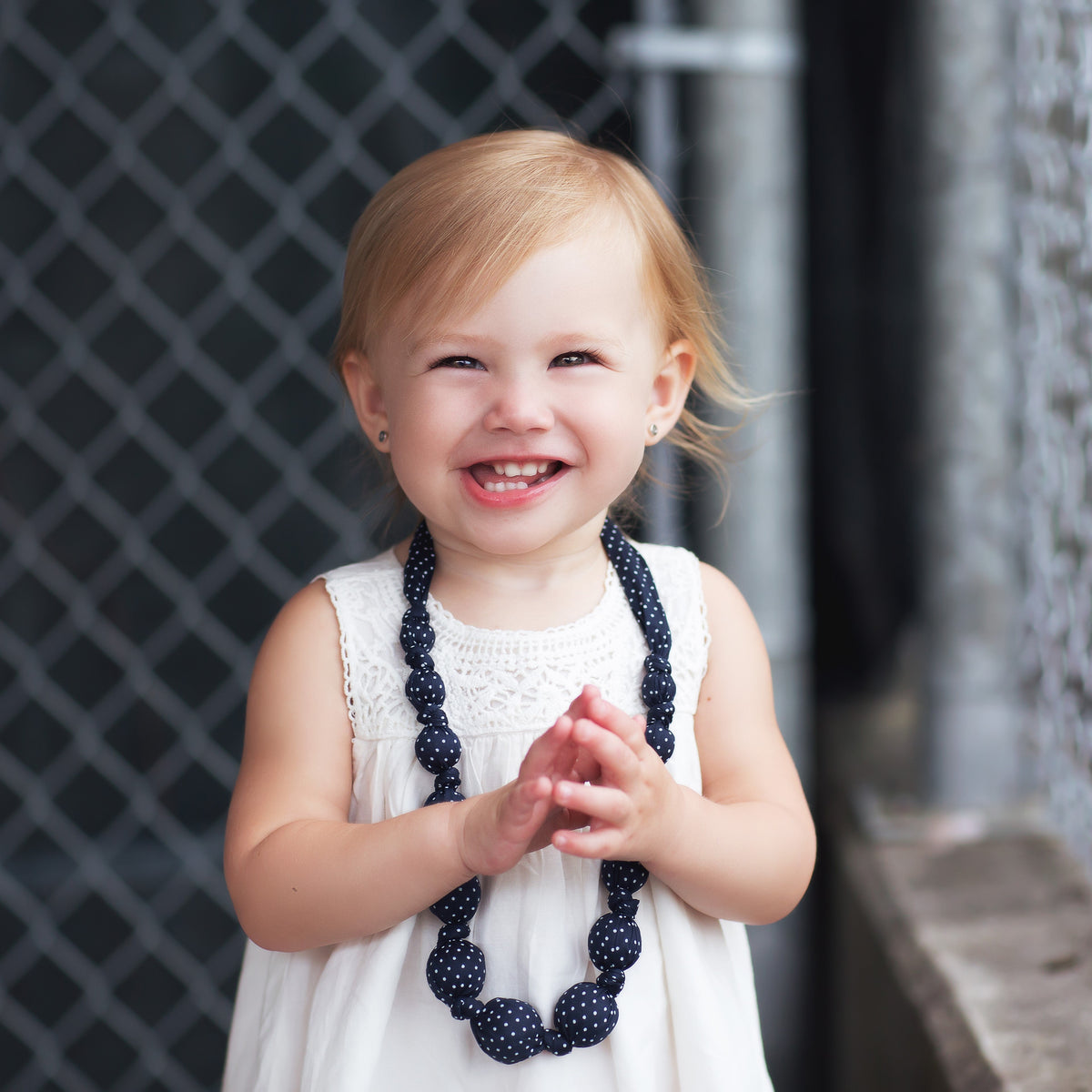 Navy polka-dot fabric beaded necklace on a child's neckline