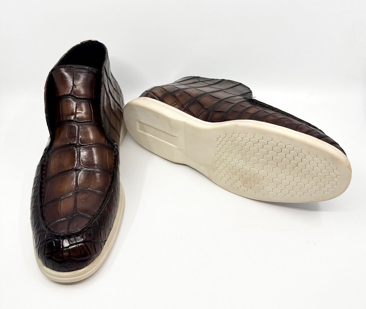 Brown alligator-embossed loafers with textured rubber outsole and white sole