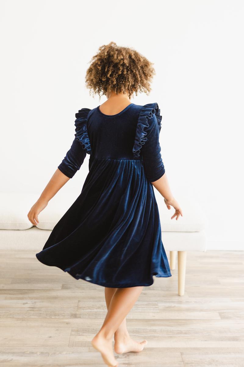 Girls navy velvet ruffle twirl dress from behind, flared skirt and gathered waist