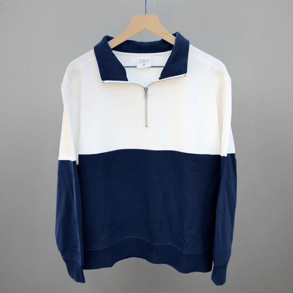 White and navy colorblock quarter-zip pullover on hanger, long sleeves