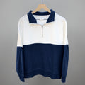 White and navy colorblock quarter-zip pullover on hanger, long sleeves