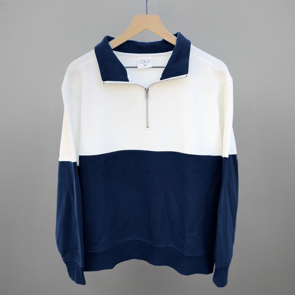 White and navy colorblock quarter-zip pullover on hanger, long sleeves