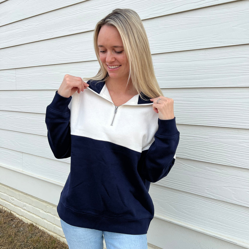 White top and navy bottom quarter-zip pullover with long sleeves and zip placket