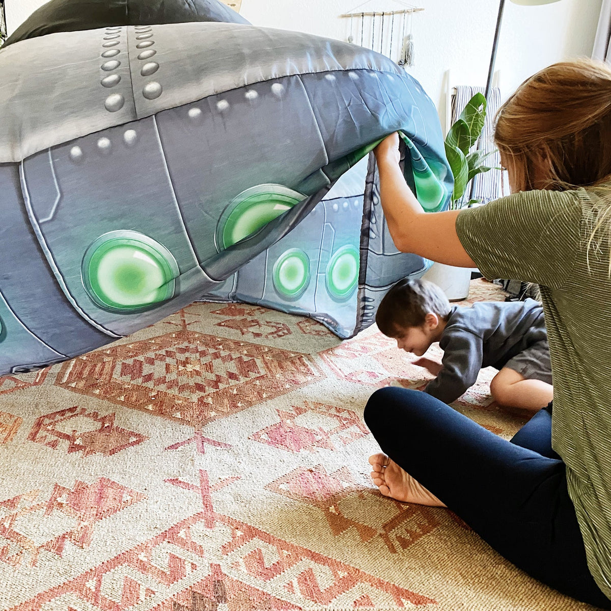 Inflatable UFO play tent doorway with green light panels on dark gray dome
