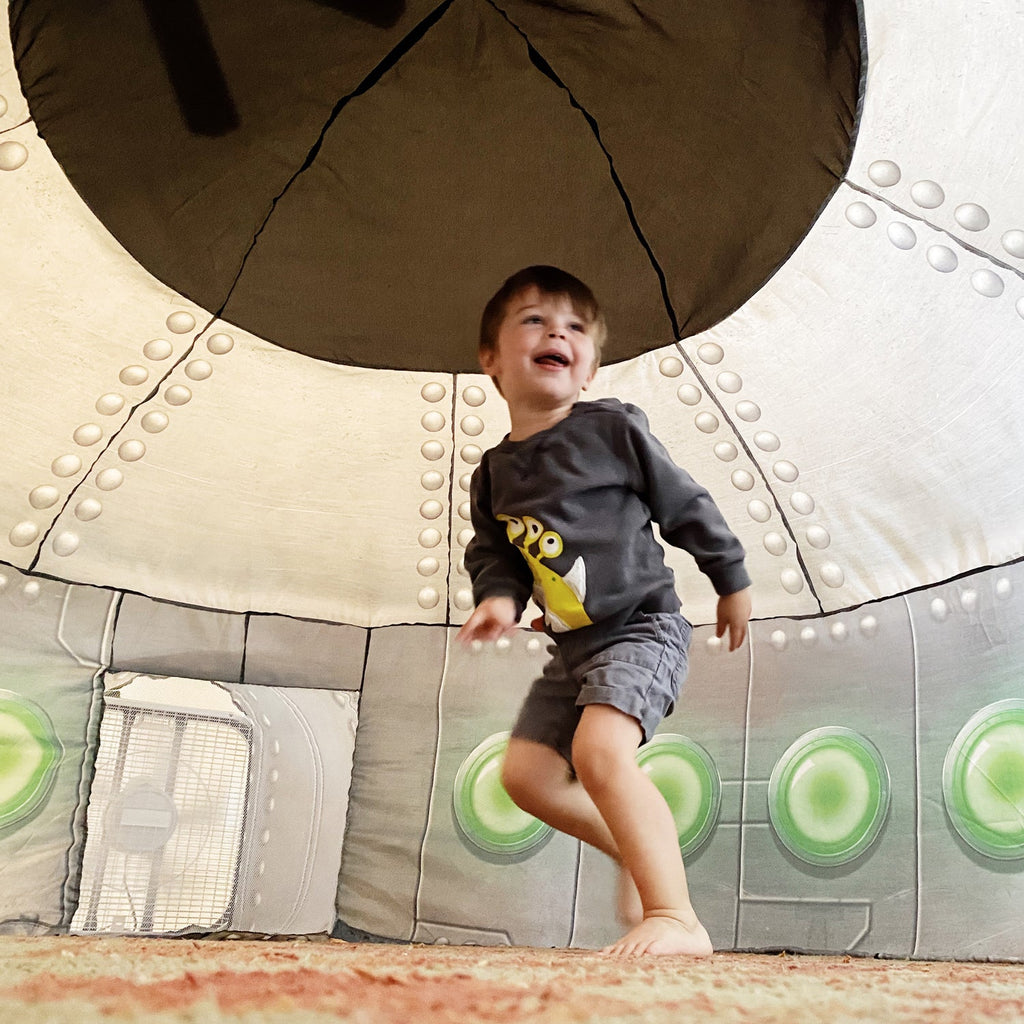 Inflatable UFO play tent interior window with green light panels on gray fabric