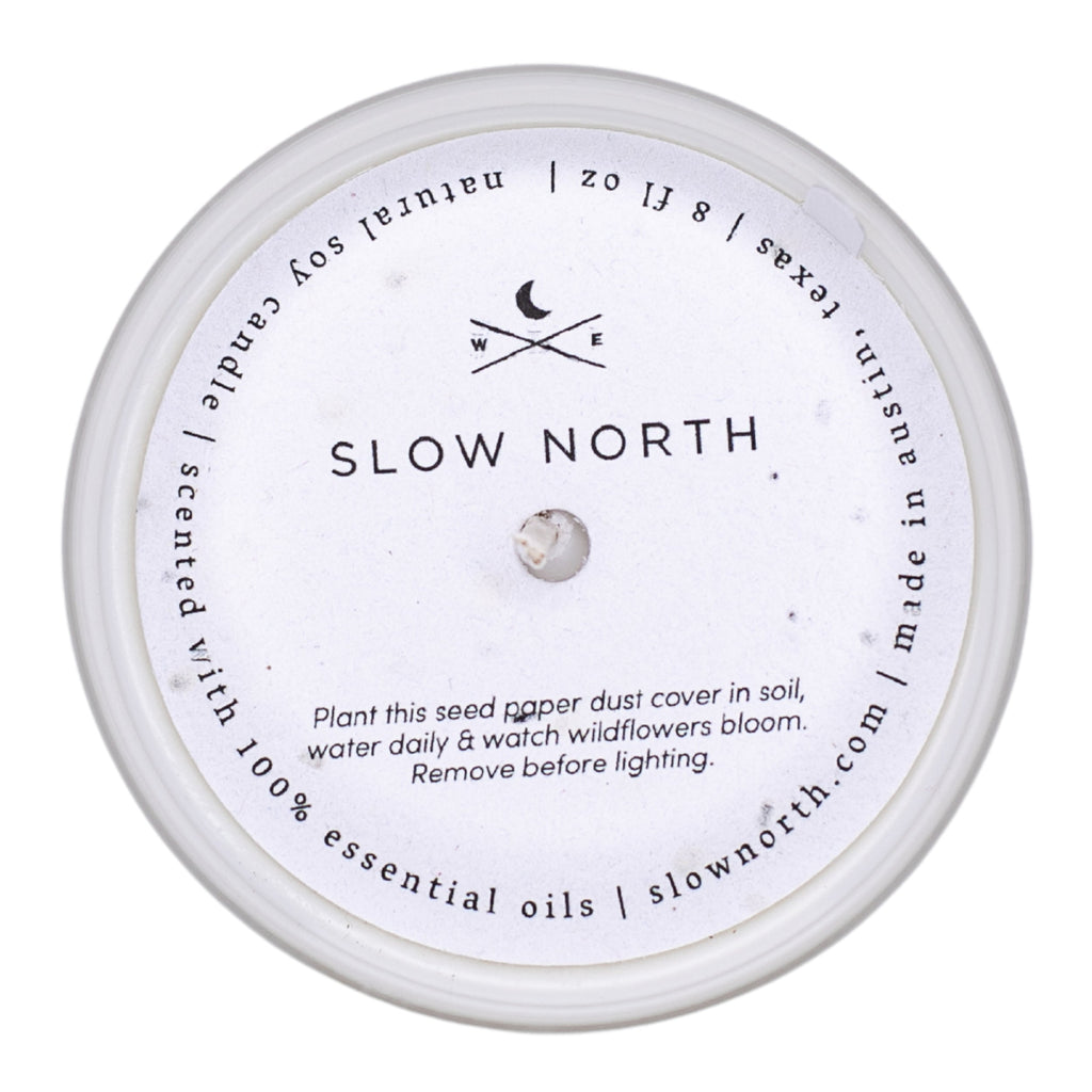 Soy candle lid with seed-pod care instructions and small central emblem