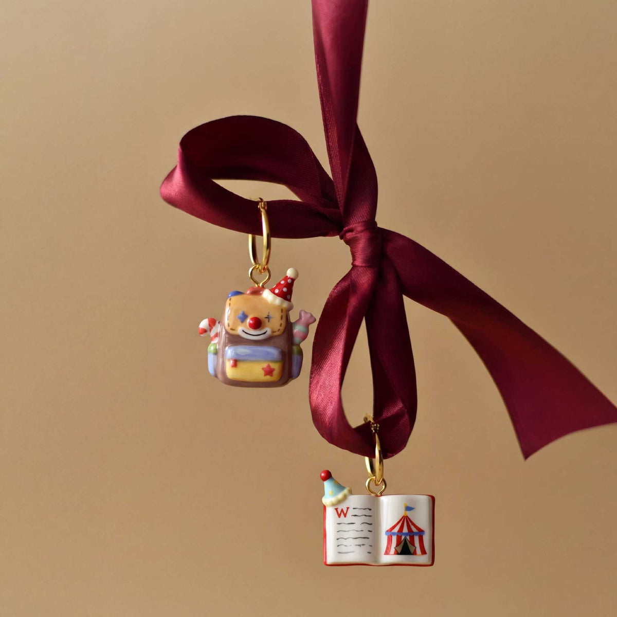 Miniature school-supply keychain charm hanging from a burgundy ribbon