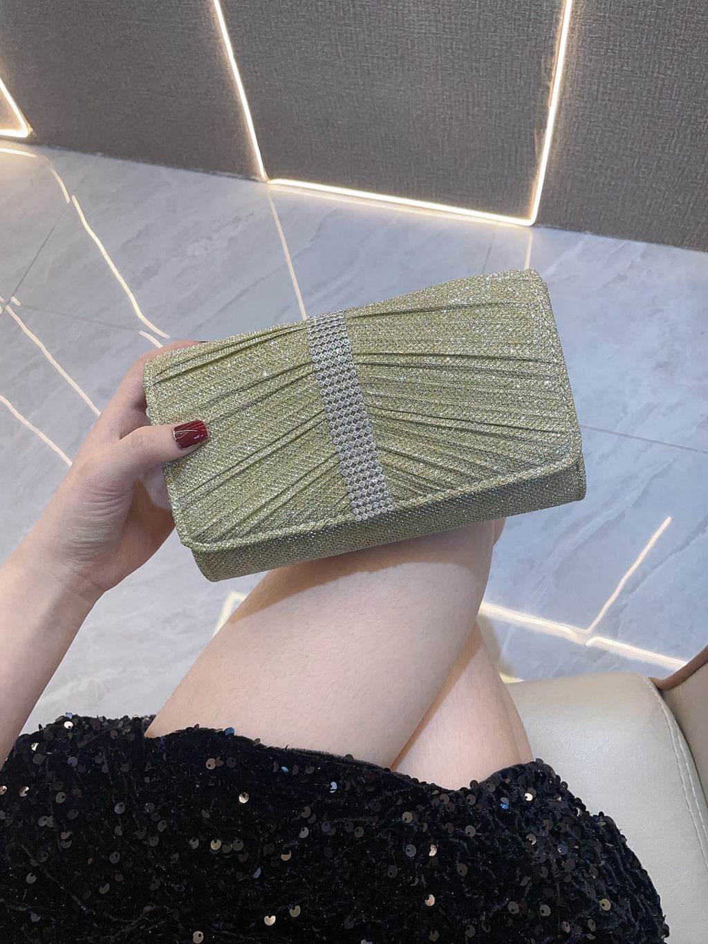 Gold diamond-textured clutch handbag with white stripe on front