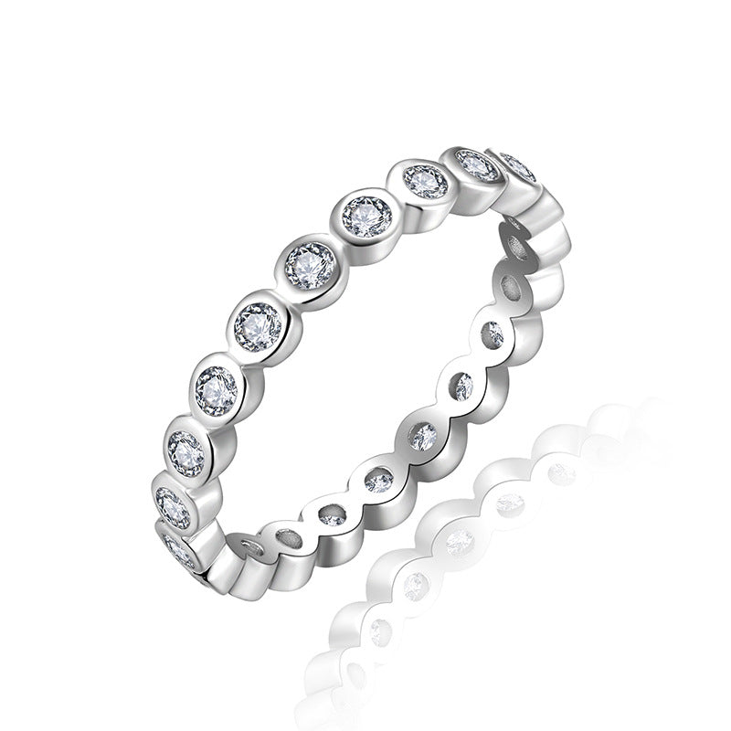 Stackable sterling silver ring set with round clear stones in scalloped bezels